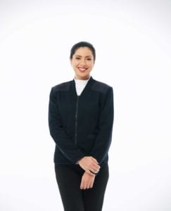 woman wearing navy v-neck zip up sweater with pockets and shoulder and elbow patches