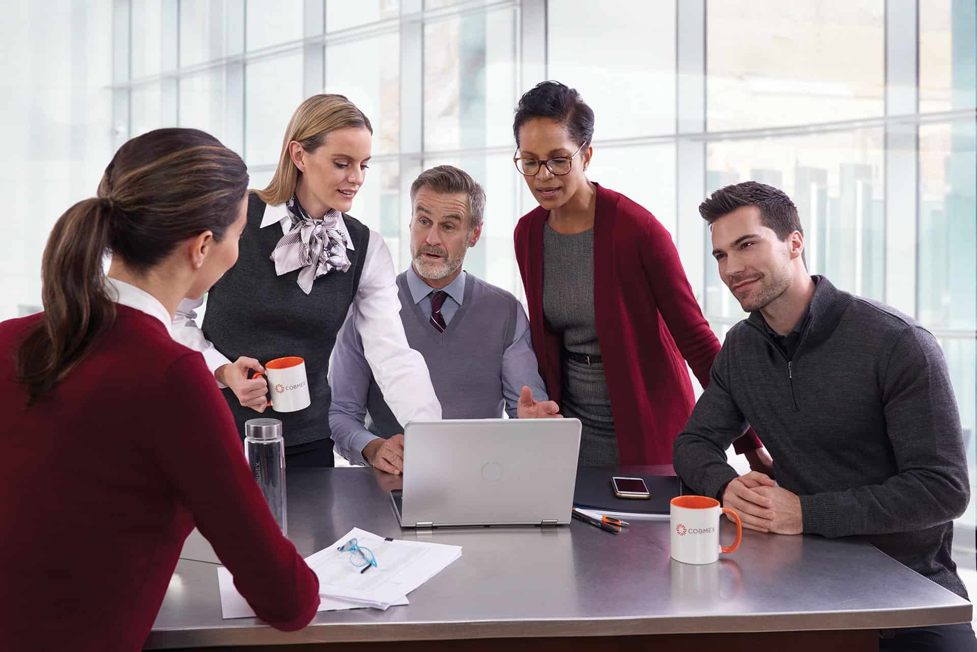Corporate employees sitting in meeting all wearing sweaters 
